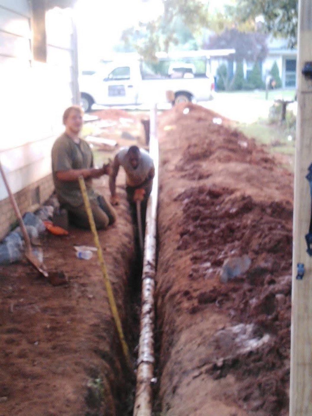 Plumbing crew completing underground drain and sewer work